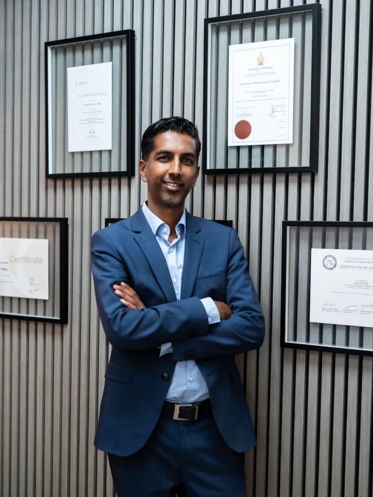 Dr Jaytesh Pillay, fellowship-trained spine surgeon, standing with international qualifications and professional certifications.